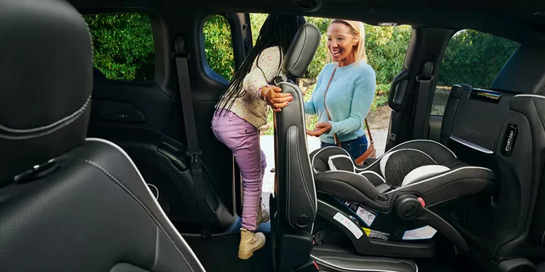 A little kid climbing out of the third row of a 2026 Chrysler Pacifica.