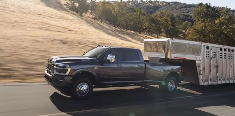 A RAM 3500 towing a trailer down the road.