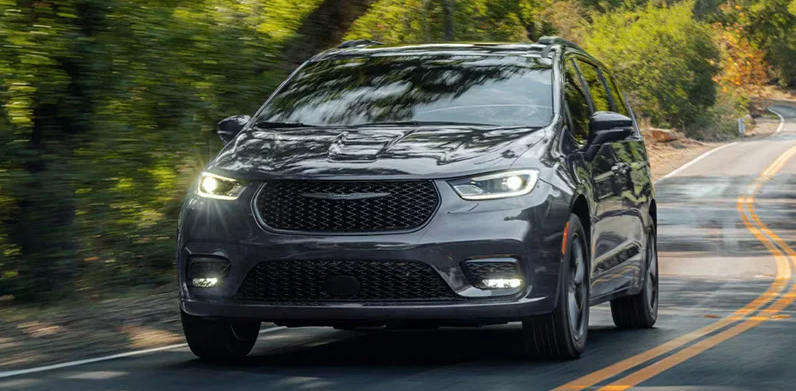 A silver 2026 Chrysler Pacifica driving down the road.