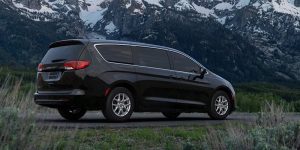 2026 Grey Chrysler Voyager stopped by in its back side profile between mountains
